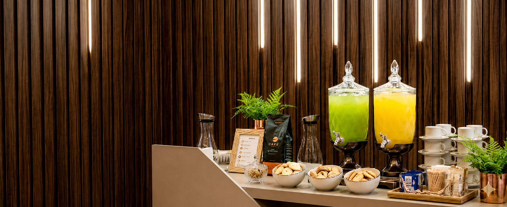 Mesa completa com bebidas, cafés e itens de recepção