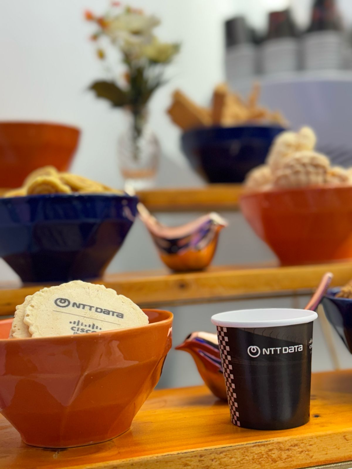 Mesa de cafeteria com biscoitos, xícaras e itens personalizados
